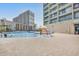 A bricked pool deck with loungers by a pool in between two resort buildings at 201 74Th Ave. N # 703, Myrtle Beach, SC 29572
