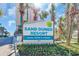Eye-catching Sand Dunes Resort sign surrounded by lush landscaping and palm trees on a sunny day at 201 74Th Ave. N # 703, Myrtle Beach, SC 29572