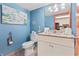 Bright bathroom featuring blue walls, granite vanity top, decorative anchor, and illuminated mirror at 201 S Ocean Blvd. # 217, Myrtle Beach, SC 29577
