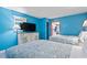 Bright bedroom with two beds, a dresser with a TV, and a view into the full kitchen at 201 S Ocean Blvd. # 217, Myrtle Beach, SC 29577