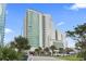 Modern high-rise building features sleek architectural design and verdant palm trees around the property at 201 S Ocean Blvd. # 217, Myrtle Beach, SC 29577