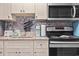 Full kitchen with stainless appliances, including a microwave, oven, and tiled backsplash at 201 S Ocean Blvd. # 217, Myrtle Beach, SC 29577