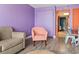 The living room includes gray wood floors, lilac walls, pink chairs and an orange door at 201 S Ocean Blvd. # 217, Myrtle Beach, SC 29577