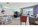 Open-concept living room with beach mural, dining area, and balcony with ocean view at 201 S Ocean Blvd. # 217, Myrtle Beach, SC 29577