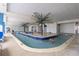 Indoor pool area with small palm tree islands and Gathering members enjoying the calm water on a sunny day at 201 S Ocean Blvd. # 217, Myrtle Beach, SC 29577