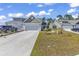 Exterior view of home with a driveway and well-maintained lawn at 205 Kinross Ct., Little River, SC 29566