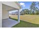 Covered patio area looking out onto a spacious green lawn with wooded backdrop at 205 Kinross Ct., Little River, SC 29566