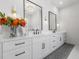 Elegant bathroom featuring double sinks, white cabinetry, modern fixtures, and a decorative flower arrangement at 208 Green Lake Dr., Myrtle Beach, SC 29572