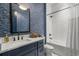 Stylish bathroom featuring a patterned blue wallpaper, sleek vanity, and a shower-tub combination with white tile at 208 Green Lake Dr., Myrtle Beach, SC 29572