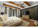Well-lit main bedroom with a dark accent wall, hardwood floors, and patio access to the backyard pool at 208 Green Lake Dr., Myrtle Beach, SC 29572