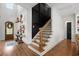 Elegant staircase with wood treads, black metal railings, and a striking black accent wall at 208 Green Lake Dr., Myrtle Beach, SC 29572