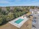 Aerial view of a community swimming pool surrounded by lush greenery and multiple parking spaces at 220 Portsmith Dr. # 2, Myrtle Beach, SC 29588