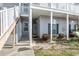 Inviting entrance to the home with covered entry, green landscaping and a white stairway at 220 Portsmith Dr. # 2, Myrtle Beach, SC 29588