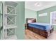 Bright bedroom features a wooden bed with drawers, a small side table, and decorative shelving at 223 Obi Lane, Surfside Beach, SC 29575