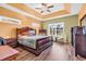 Spacious main bedroom featuring a large window, wood-look flooring, tray ceiling and a ceiling fan at 223 Obi Lane, Surfside Beach, SC 29575