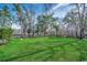 A large green backyard with mature trees, a black iron fence, and manicured landscaping at 232 Wahee Pl., Conway, SC 29527