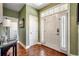 Bright foyer with hardwood floors, a white front door with sidelights, and green walls at 232 Wahee Pl., Conway, SC 29527