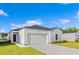Charming single-story home with a two-car garage, green lawn, and bright blue sky at 263 Warner Crossing Way, Loris, SC 29569