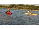 A couple paddles in kayaks on a calm river bordered by lush trees at 263 Warner Crossing Way, Loris, SC 29569