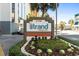 Exterior sign for The Strand boutique resort with address and well-maintained landscaping at 2700 N Ocean Blvd. # 1053, Myrtle Beach, SC 29577