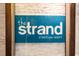 The Strand logo for a boutique resort in bold white letters set on a blue background at 2700 N Ocean Blvd. # 1053, Myrtle Beach, SC 29577