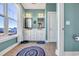 Charming bathroom with double vanity, framed mirrors, decorative rugs, and bright natural light at 3 Half Shell Ct., Pawleys Island, SC 29585