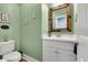 Chic powder room featuring a modern vanity, colorful mirror, and fresh green paint at 3 Half Shell Ct., Pawleys Island, SC 29585