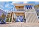 Exterior view of garage with upstairs porch featuring wood ceiling and adjacent outdoor seating at 3 Half Shell Ct., Pawleys Island, SC 29585