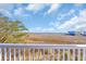 Expansive view from the back porch overlooking grassy marshland and distant homes on a sunny day at 3 Half Shell Ct., Pawleys Island, SC 29585