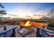 Relaxing patio with Adirondack chairs, a fire pit, and a beautiful backdrop of the marsh at sunset at 3 Half Shell Ct., Pawleys Island, SC 29585