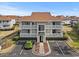 Exterior view of a well-maintained two-story condo with a parking lot and manicured landscaping at 300 Shorehaven Dr. # W-3, North Myrtle Beach, SC 29582