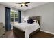 Comfortable bedroom with a wood bed frame, wood floors, and bright window with blue curtains at 3120 Bayhaven Dr., Myrtle Beach, SC 29579