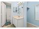 Well-lit bathroom featuring a white vanity with a single sink, a bathtub, and blue wall paint at 310 5Th Ave. N # 206, Surfside Beach, SC 29575