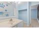 Bathroom featuring a white single-sink vanity, a mirror with turtle decals, and a closet at 310 5Th Ave. N # 206, Surfside Beach, SC 29575