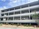 Multi-level condo building featuring private balconies and a well-maintained landscaped yard on a sunny day at 310 5Th Ave. N # 206, Surfside Beach, SC 29575