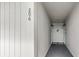 Hallway entrance featuring unit number 206, carpeted floors, modern sconces, and a decorative seal on the front door at 310 5Th Ave. N # 206, Surfside Beach, SC 29575