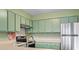 Cozy kitchen featuring stainless steel appliances and bright green cabinetry at 310 5Th Ave. N # 206, Surfside Beach, SC 29575