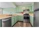 Well-lit kitchen with stainless steel appliances, green cabinetry, and wood-look flooring at 310 5Th Ave. N # 206, Surfside Beach, SC 29575