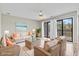 Cozy living room with wicker furniture, beach-themed decor, and sliding glass doors to balcony, filled with sunlight at 310 5Th Ave. N # 206, Surfside Beach, SC 29575