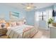 Bright bedroom with a wicker bed frame, ceiling fan, and a large window for ample natural light at 310 5Th Ave. N # 206, Surfside Beach, SC 29575