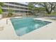 Community pool area with lounge chairs, pool entrance stairs, and surrounding trees at 310 5Th Ave. N # 206, Surfside Beach, SC 29575