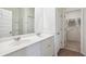 Bright bathroom featuring a double vanity, sleek mirrors, white cabinets, and a walk-in closet access at 312 Brackish Dr. # 312, Myrtle Beach, SC 29588