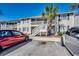 Exterior of a two-story condo building featuring white staircases and a palm tree at 3555 Highway 544 # 4-C, Conway, SC 29526