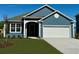 Charming blue home features a two-car garage and manicured lawn at 399 Wingspan Ct., Myrtle Beach, SC 29588