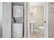 Bathroom featuring pedestal sink, toilet, and a closet with stacked washer and dryer at 401 25Th Ave. S, North Myrtle Beach, SC 29582