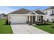 Attractive home with a two-car garage, a stone facade, and a well-kept front yard at 4295 Falls Oaks St., Myrtle Beach, SC 29579