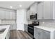 Corner view of kitchen featuring gray cabinets, stainless appliances and gas range at 4295 Falls Oaks St., Myrtle Beach, SC 29579