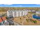Aerial view of multi-story condo complex with multiple units overlooking lush, green surroundings at 4440 Nassau Ct. # D-507, Little River, SC 29566