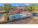 Aerial view of a pool area with a clubhouse, lounge chairs, and palm trees near a condo complex at 4440 Nassau Ct. # D-507, Little River, SC 29566