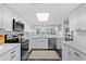 Chic kitchen with white cabinets, stainless steel appliances, and sleek black flooring at 4440 Nassau Ct. # D-507, Little River, SC 29566